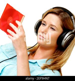 Nahaufnahme einer Geschäftsfrau, die Kopfhörer trägt und eine CD ansieht Fall Stockfoto
