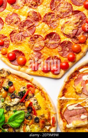 Verschiedene Arten von Pizzen im Sortiment mit grünem Basilikum, Nahaufnahme Stockfoto