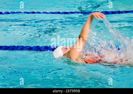 Seitenansicht einer jungen Frau, die in einem Schwimmbad schwimmen Stockfoto