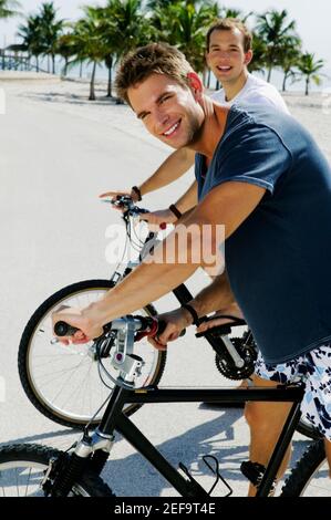 Porträt zweier junger Männer auf Fahrrädern Stockfoto