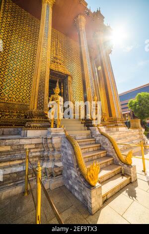 Tempelwächter und Treppe außerhalb Phra Mondop in Wat Phra Kaew im Grand Palace Bereich in Bright Sunny Day in Bangkok, Thailand Stockfoto