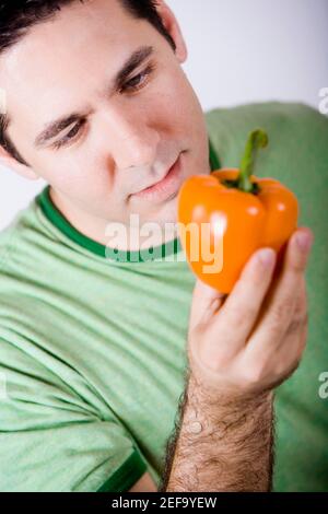 Nahaufnahme eines Mannes mit mittlerem Erwachsenen und orangefarbener Glocke Pfeffer Stockfoto