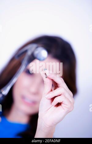 Porträt einer jungen Frau mit einem Hammer und einem Nagel Stockfoto