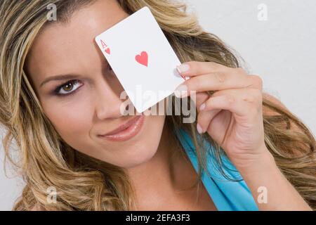 Porträt einer jungen Frau mit einer Ass-Karte und Lächelnd Stockfoto