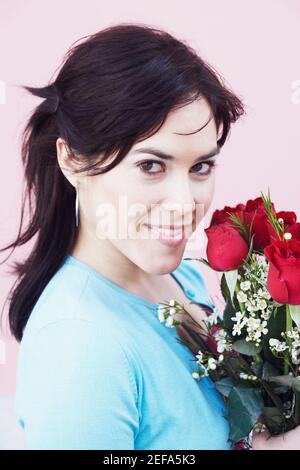 Porträt einer jungen Frau hält einen Strauß Rosen Stockfoto