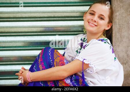 Porträt einer jungen Frau, die auf einer Kante sitzt Stockfoto