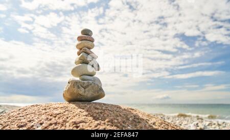 Hoher Steinstapel im Gleichgewicht als Zen und buddhismus Konzept am Strand Stockfoto