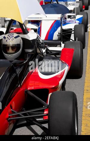 Reihe von Rennwagen auf einer Rennstrecke Stockfoto