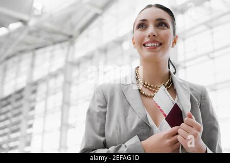 Nahaufnahme einer Geschäftsfrau, die einen Reisepass mit einem Flugzeug legt Ticket in ihrer coatÅ½s Tasche Stockfoto