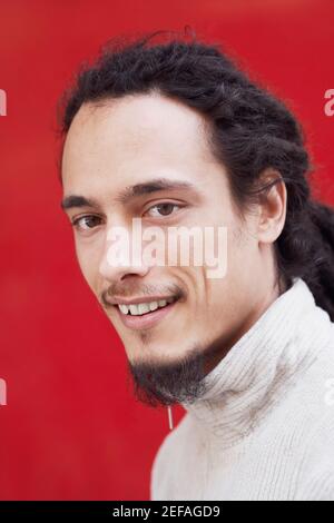Porträt eines jungen Mannes mit Dreadlocks lächelnd Stockfoto