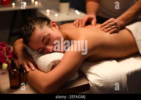 Lächelnde Frau Masseurin macht Rückenmassage im Spa-Center Stockfoto