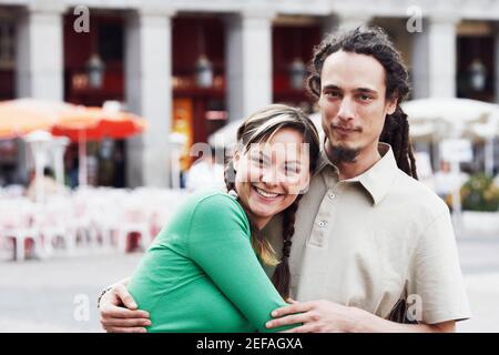 Porträt eines jungen Paares umarmen einander und lächelnd Stockfoto
