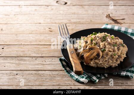 Risotto mit Pilzen auf Holztisch Stockfoto