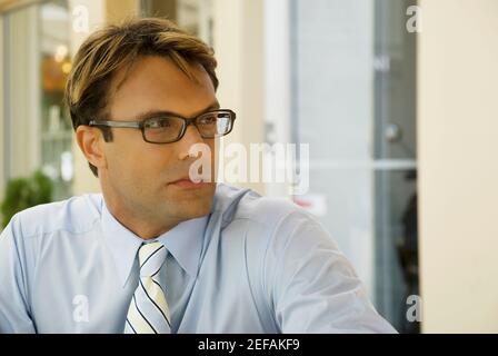 Nahaufnahme eines Geschäftsmannes, der Brillen trägt und denkt Stockfoto