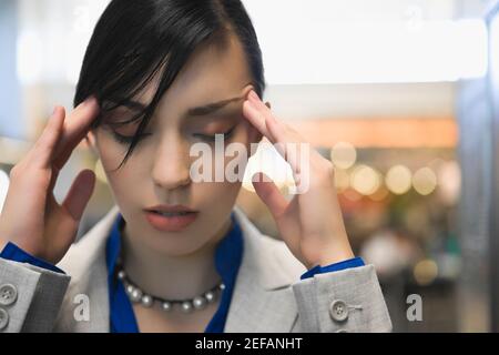 Nahaufnahme einer Geschäftsfrau, die unter Kopfschmerzen leidet Stockfoto