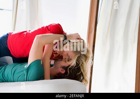 Seitenansicht eines jungen Paares romancing auf einer couch Stockfoto