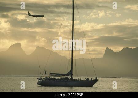 Flugzeug, das über einem Segelboot fliegt, Moorea, Tahiti, Gesellschaftsinseln, Französisch-Polynesien Stockfoto