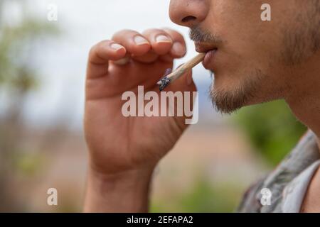 Nahaufnahme Porträt eines Mannes, der ein Gelenk raucht Marihuana Stockfoto
