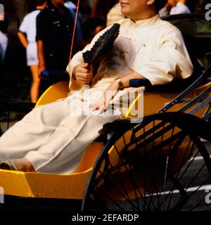 Nahaufnahme eines mittelerwachsenen Mannes, der auf einer Rikscha sitzt, Singapur Stockfoto