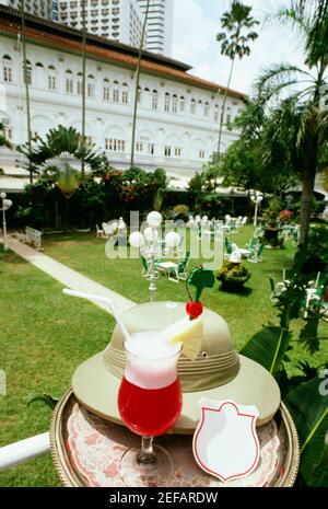 Singapur Sling mit Hut auf einem Tisch im Garten, Raffles Hotel, Singapur City, Singapur Stockfoto