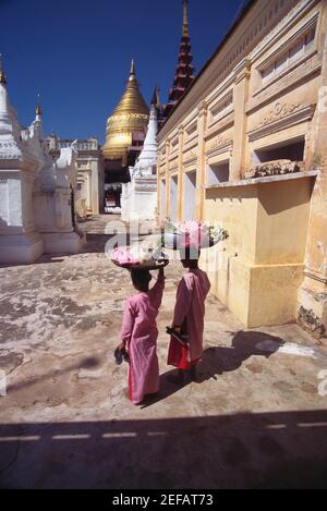 Rückansicht von zwei Nonnen mit Körben auf dem Kopf, Bagan, Myanmar Stockfoto