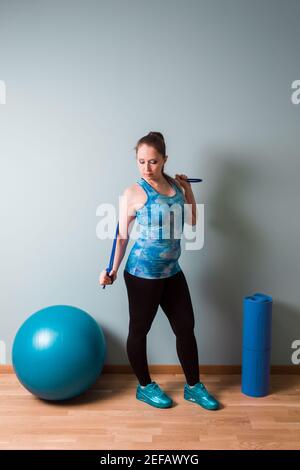 Frau stehen mit quipment für Fitness oder Yoga in der Zimmer Stockfoto