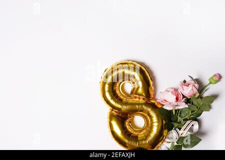 8 Goldnumber Ballon mit rosa Blumenrosen. Weißer Hintergrund mit Copyspace. Frau Urlaub und 8 märz Konzept. Grußkarte Stockfoto