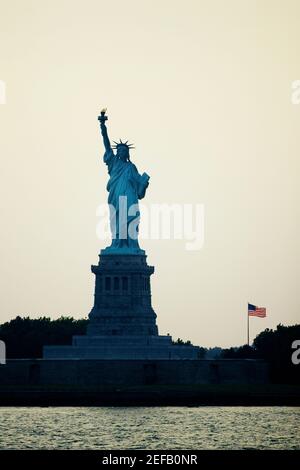 Silhouette einer Statue in der Abenddämmerung, Freiheitsstatue, New York City, New York State, USA Stockfoto