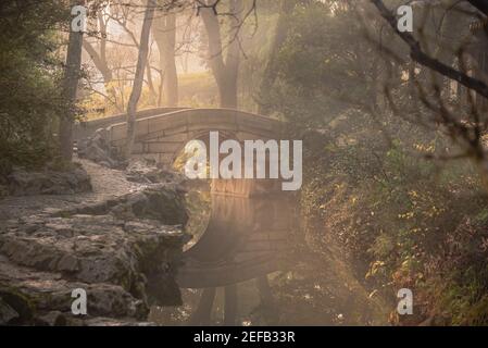 chinesische Brücke in Suzhou, Jiangsu, China im Nebel am frühen Morgen Stockfoto