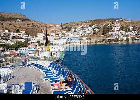 Hochwinkel Ansicht der Touristen auf Liegestühlen auf dem Deck eines Schiffes ruhen, Skala, Patmos, Dodekanes Inseln, Griechenland Stockfoto