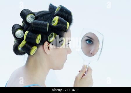 Nahaufnahme einer reifen Frau, die in einen Handspiegel schaut Stockfoto