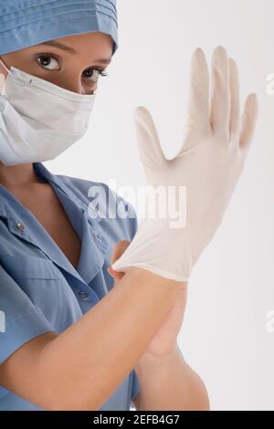 Weibliche Chirurgen trägt einen chirurgischen Handschuh Stockfoto