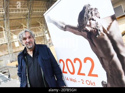 Oberammergau, Deutschland. Februar 2021, 17th. Der Leiter des Passionsspiels Christian Stückl steht neben dem neuen Plakat zur Passion 2022. Heute wurde das "Haar- und Bartdekret" für das Passionsspiel angekündigt, das wegen Corona auf 2022 verschoben wurde. Nach der Tradition sind alle Darsteller am Aschermittwoch im Jahr vor der Passion aufgerufen, ihre Haare und Bärte wachsen zu lassen. Quelle: Angelika Warmuth/dpa/Alamy Live News Stockfoto