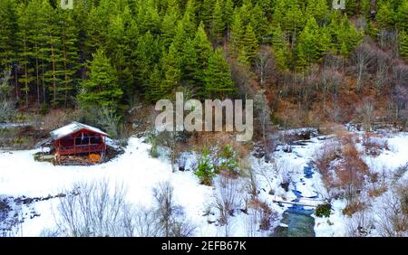 Luftdrohne Foto von hölzernen Berghütte in Rhodopen, an einem schönen Wintertag. Vogelperspektive. Stockfoto