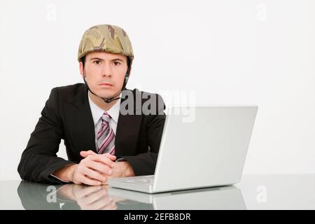 Porträt eines Geschäftsmannes mit Armeehelm Stockfoto