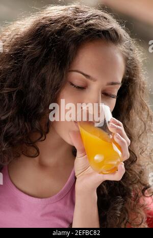 Nahaufnahme einer jungen Frau, die ein Glas Saft trinken Stockfoto