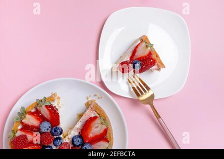Käsekuchen mit frischen Beeren auf dem rosa Hintergrund Stockfoto