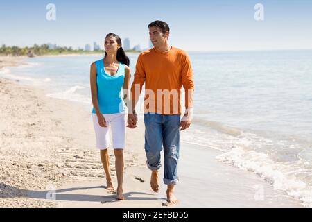 Junge Frau und ein Mann mittleren Erwachsenen, die auf dem Strand Stockfoto