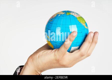 Nahaufnahme einer personÅ½s Hand, die einen Globus hält Stockfoto