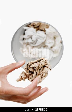 High-Winkel-Ansicht einer womanÅ½s Hand werfen eine zerknittert Blatt Papier in einem Papierkorb Stockfoto
