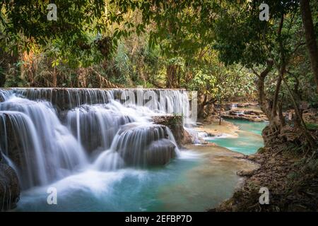 Kwang Si Wasserfall lange Exposition türkis Wasser Wald Hintergrund Stockfoto