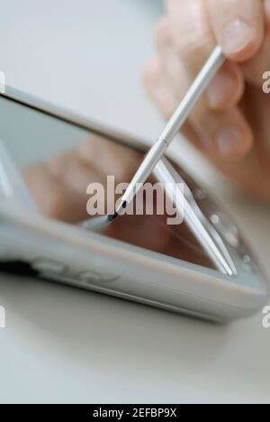 Nahaufnahme einer personŽs Hand mit einem Assistenten für persönliche Daten Stockfoto