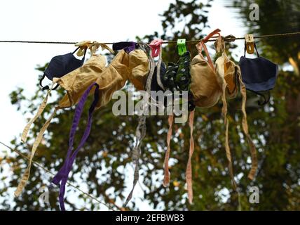 Bunte hausgemachte Masken hängen draußen Stockfoto