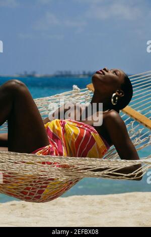 Desiree Lynes trägt einen Sarong liegt auf einer Hängematte, Crystal Palace Hotel, Nassau, Bermuda Stockfoto