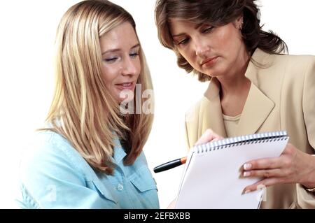 Nahaufnahme von zwei Sekretärinnen, die auf ein Notizblock schauen Stockfoto