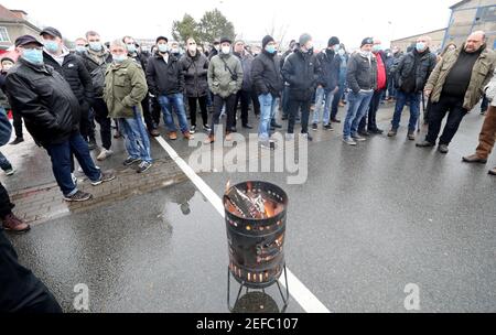 17. Februar 2021, Mecklenburg-Vorpommern, Warnemünde: Mitarbeiter versammeln sich vor der MV Werft in Warnemünde zu einer Protestkundgebung. Die Werftarbeiter sind dem Aufruf der IG Metall gefolgt, die ihre Forderungen an die Werften MV betont, die mit Arbeitsplatzabbau bedroht sind. Sie fordern, dass die Bundesregierung so schnell wie möglich Geld aus dem Fonds für wirtschaftliche Stabilisierung zur Verfügung stellt und die Kurzzeitarbeitsregelung verlängert. Foto: Bernd Wüstneck/dpa-Zentralbild/dpa Stockfoto