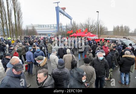 17. Februar 2021, Mecklenburg-Vorpommern, Warnemünde: Mitarbeiter versammeln sich vor der MV Werft in Warnemünde zu einer Protestkundgebung. Die Werftarbeiter sind dem Aufruf der IG Metall gefolgt, die ihre Forderungen an die Werften MV betont, die mit Arbeitsplatzabbau bedroht sind. Sie fordern, dass die Bundesregierung so schnell wie möglich Geld aus dem Fonds für wirtschaftliche Stabilisierung zur Verfügung stellt und die Kurzzeitarbeitsregelung verlängert. Foto: Bernd Wüstneck/dpa-Zentralbild/dpa Stockfoto