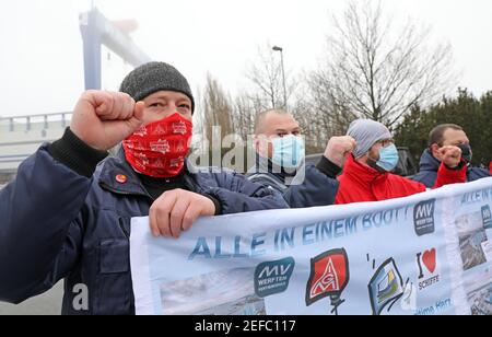 17. Februar 2021, Mecklenburg-Vorpommern, Warnemünde: Mitarbeiter versammeln sich vor der Werft MV Werft in Warnemünde zu einer Protestkundgebung mit einem Transparent mit der Aufschrift "alles in einem Boot!". Die Werftarbeiter sind dem Aufruf der IG Metall gefolgt, die ihre Forderungen an die Werften MV betont, die mit Arbeitsplatzabbau bedroht sind. Sie fordert, dass die Bundesregierung so schnell wie möglich Geld aus dem Fonds für wirtschaftliche Stabilisierung zur Verfügung stellt und die Kurzzeitarbeitsregelung verlängert. Foto: Bernd Wüstneck/dpa-Zentralbild/dpa Stockfoto