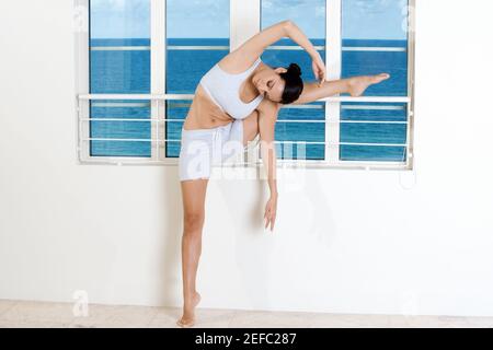 Junge Frau, die Dehnung Stockfoto
