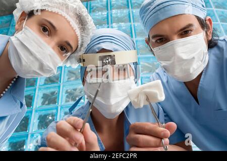 Zwei männliche Chirurgen und ein männlicher Chirurg bei einer Operation Zimmer Stockfoto